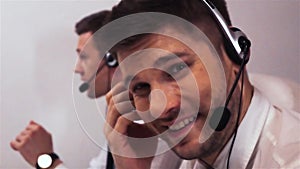 Two businessmen with headsets talking on voice call centre technical support