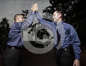 Two businessmen high fiving each other