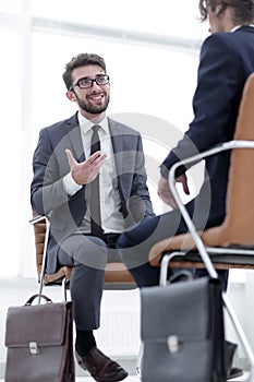 Two businessmen holding briefcases near themselves