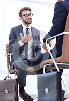 Two businessmen holding briefcases near themselves