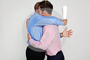 Two businessmen hugging