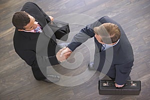 Two businessmen indoors shaking hands