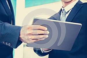 Two businessmen looking at tablet pc, vintage tone