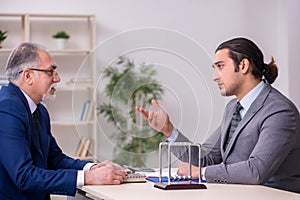 Two businessmen and meditation balls on the table