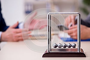 Two businessmen and meditation balls on the table