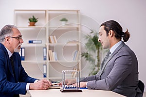 Two businessmen and meditation balls on the table