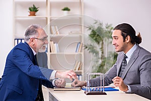 Two businessmen and meditation balls on the table