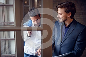 Two businessmen in office studding business offer