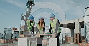 Two businessmen s in a suit and one female architect analyzing the project of a new Apartament building In construction