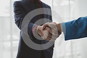 Two businessmen shake hands after a joint meeting, business venture handshake saluting, business meeting, presentation of business