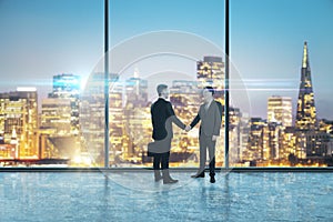 Two businessmen shaking hands in an empty big office room with big windows and night city view, reaching an agreement.