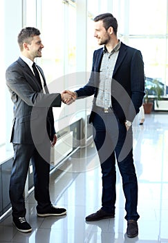 two businessmen shaking hands in office