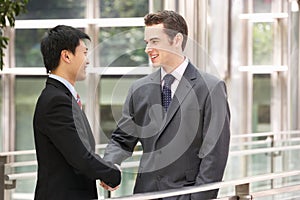 Two Businessmen Shaking Hands Outside Office