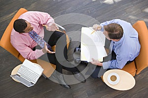 Two businessmen sitting indoors having a meeting