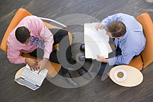 Two businessmen sitting indoors having a meeting