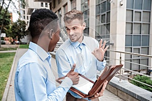 Two businessmen smiling and talking.