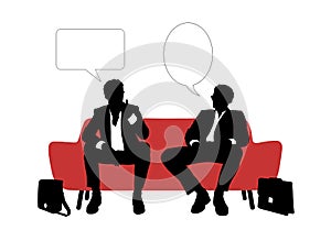 Two businessmen speaking seated on red sofa