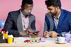 Two businessmen speaking and working at the office