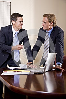 Two businessmen in suits working in boardroom