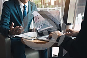 Two businessmen are talking about the results of operations in the company financial statements on the computer screen