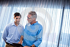 Two businessmen using a tablet computer