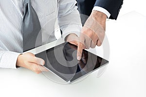 Two businessmen using tablet computer with one hand touching screen