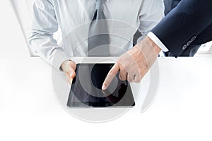 Two businessmen using tablet computer with one hand touching screen