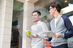 Two businessmen walking and talking in the city