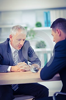 Two businessmen watching crystal ball