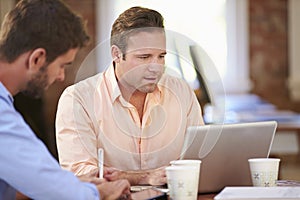 Two Businessmen Working At Desk Together