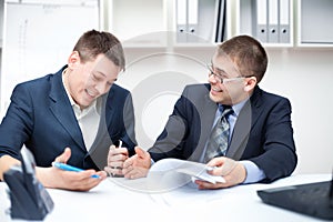 Two businessmen working together with computer