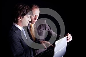 Two businessmen working together on a laptop