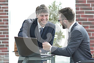 Two businessmen working together using laptop on business meeting in office