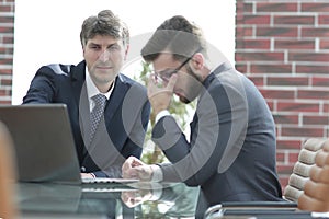 Two businessmen working together using laptop on business meeting in office