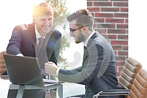 Two businessmen working together using laptop on business meeting in office