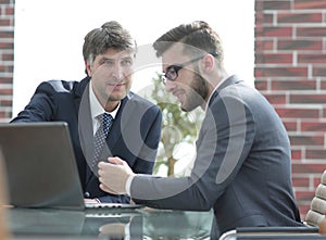 Two businessmen working together using laptop on business meeting in office