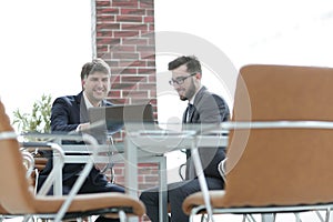 Two businessmen working together using laptop on business meeting in office