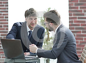 Two businessmen working together using laptop on business meeting in office