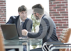 Two businessmen working together using laptop on business meeting in office