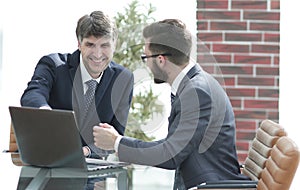 Two businessmen working together using laptop on business meeting in office