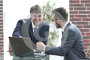 Two businessmen working together using laptop on business meeting in office