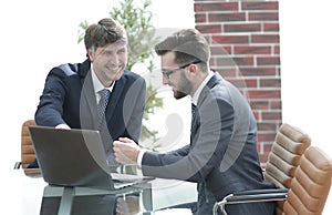 Two businessmen working together using laptop on business meeting in office