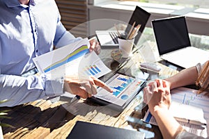 Two Businesspeople Analyzing Graph On Digital Tablet