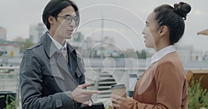 Two businesspeople Asian man and Middle Eastern woman speaking holding to go coffee then doing high-five and leaving