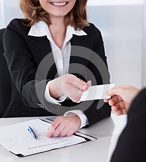 Two businesspeople exchanging visiting card