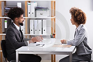 Two Businesspeople Having Conversation In Office