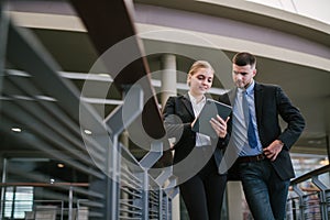 Two businesspeople looking at tablet outdoors. meeting plan. Communication concept