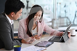 Two businesspeople sitting in office and talking about marketing strategy planning.