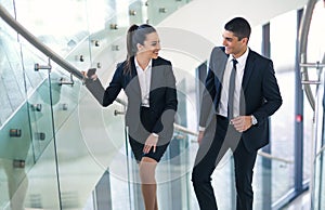 Two businesspeople talking as they walk