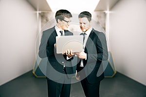 Two businesspeople using laptop together